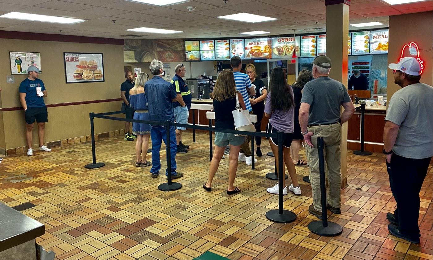Travelers queuing for food at a highway service-area counter