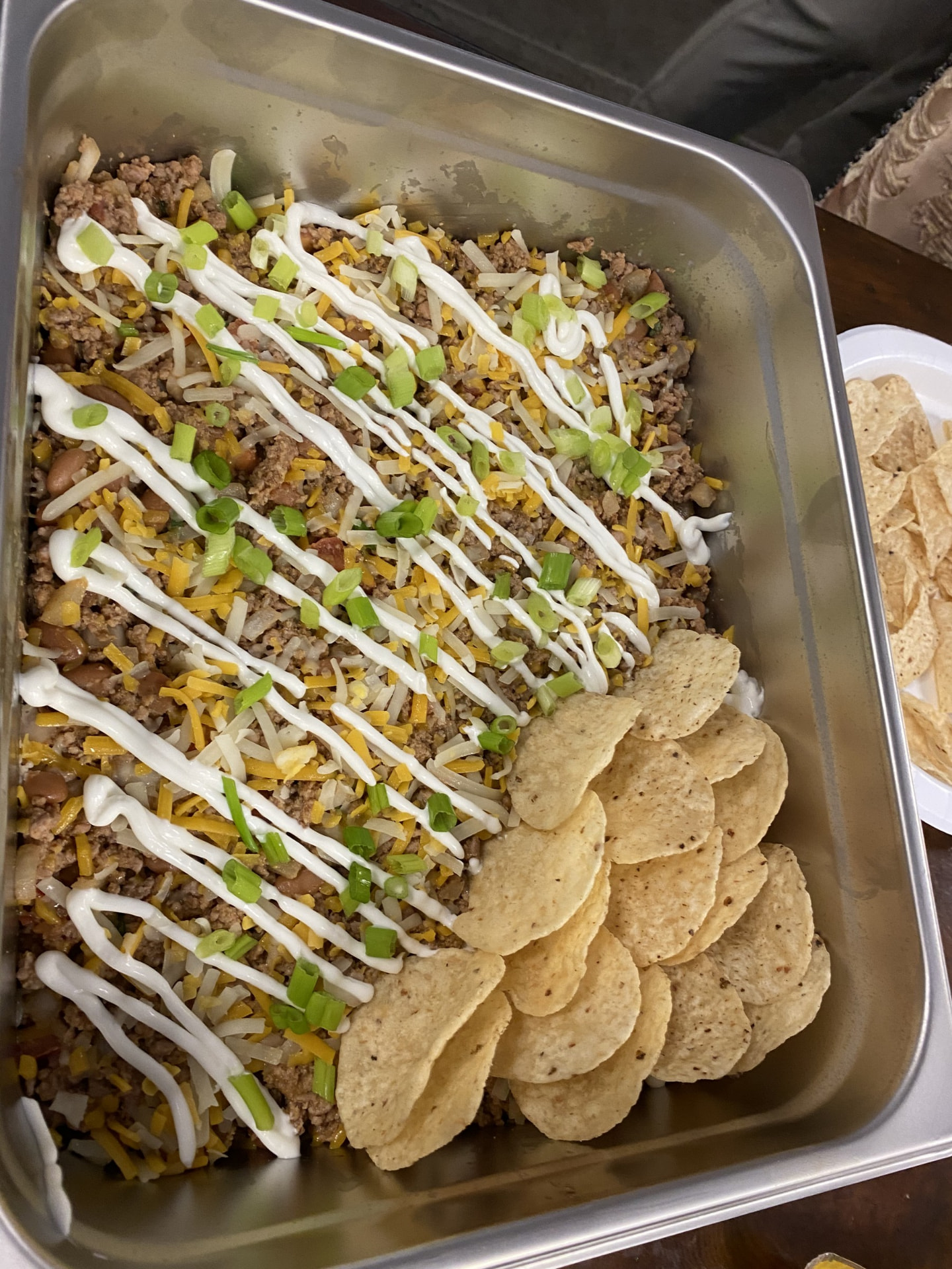 Taco casserole prepared by Robby One with cheese, green onions and tortilla chips